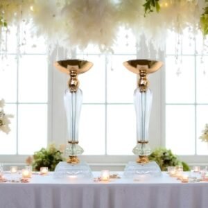 Lot de 2 vases bougeoirs transparents à détails dorés, sur une table décorée de fleurs et bougies – centre de table élégant pour mariage ou réception.